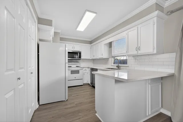 a kitchen with white cabinets and white appliances