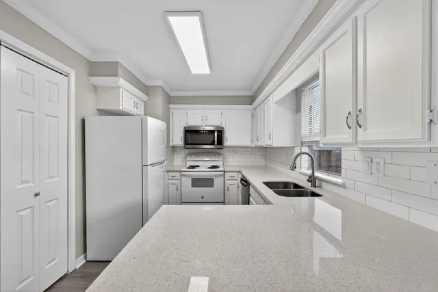 a kitchen with stainless steel appliances granite countertop a refrigerator sink and stove