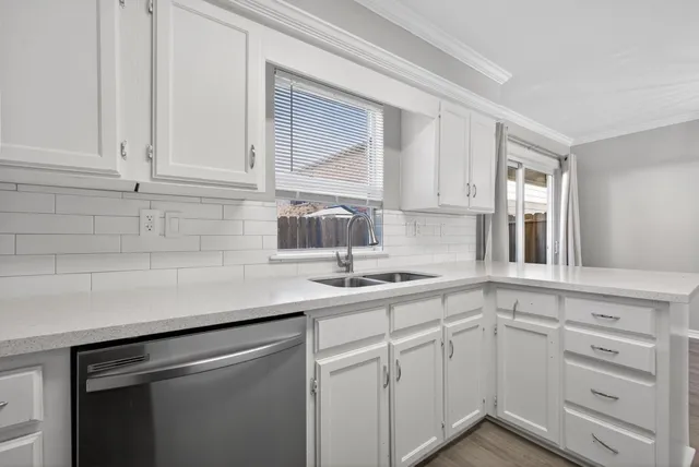 a kitchen with white cabinets and a sink