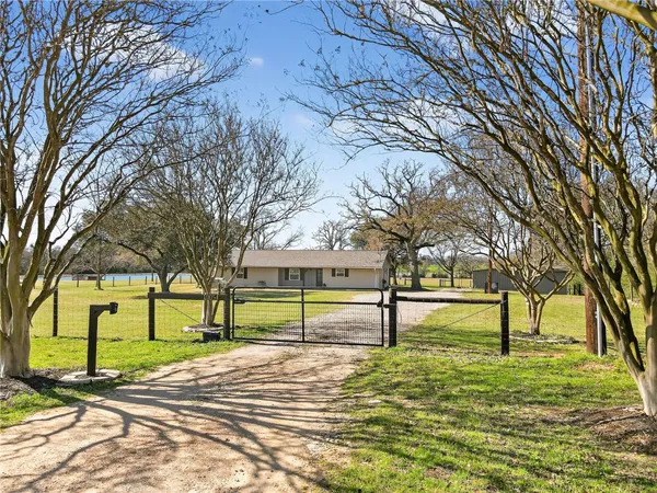 a house view with swimming pool and trees in the background