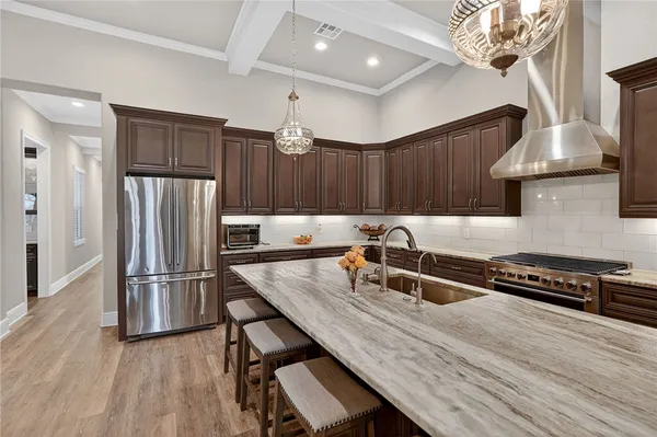a kitchen with granite countertop a table chairs stainless steel appliances and wooden floor