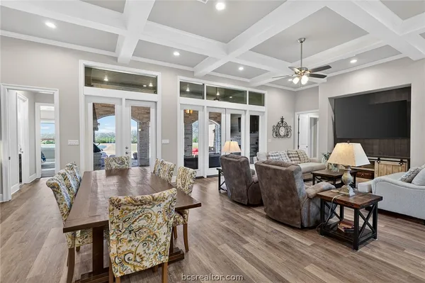 a living room with furniture a flat screen tv and wooden floor