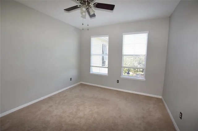 an empty room with a window and a ceiling fan