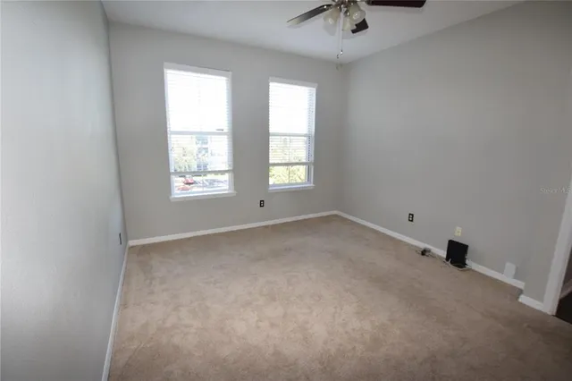 a view of an empty room and a ceiling fan