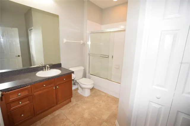 a bathroom with a granite countertop sink toilet a mirror and a shower