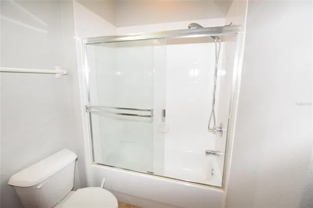 a bathroom with a shower a toilet and a window