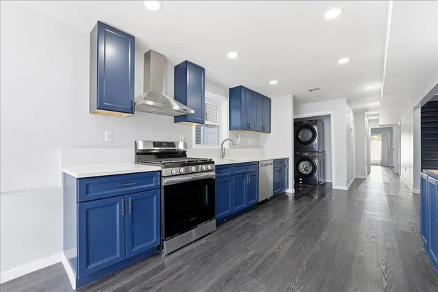 a kitchen with stainless steel appliances granite countertop a stove a refrigerator a sink dishwasher and a oven with wooden floor