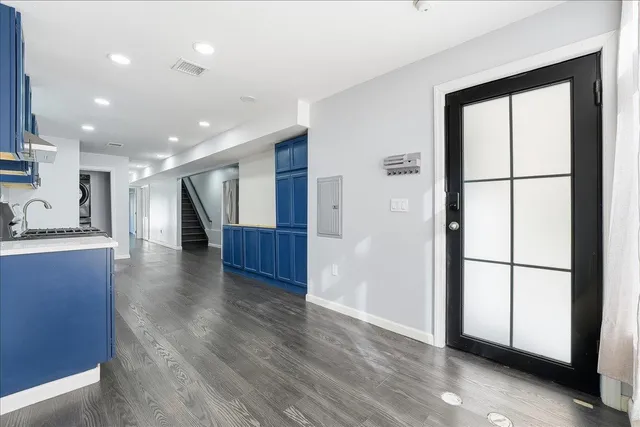 a view of kitchen with stainless steel appliances wooden floor and large window
