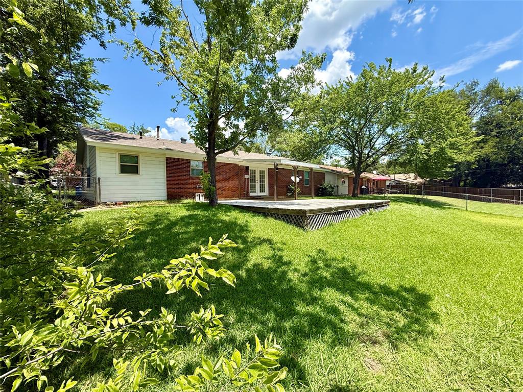 160 Bob White Road Denison, TX 75020 - Photo 28 of 29 Expansive backyard featuring a large wooden deck, mature trees, a red brick exterior, and white siding