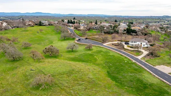 an aerial view of residential houses with outdoor space and river