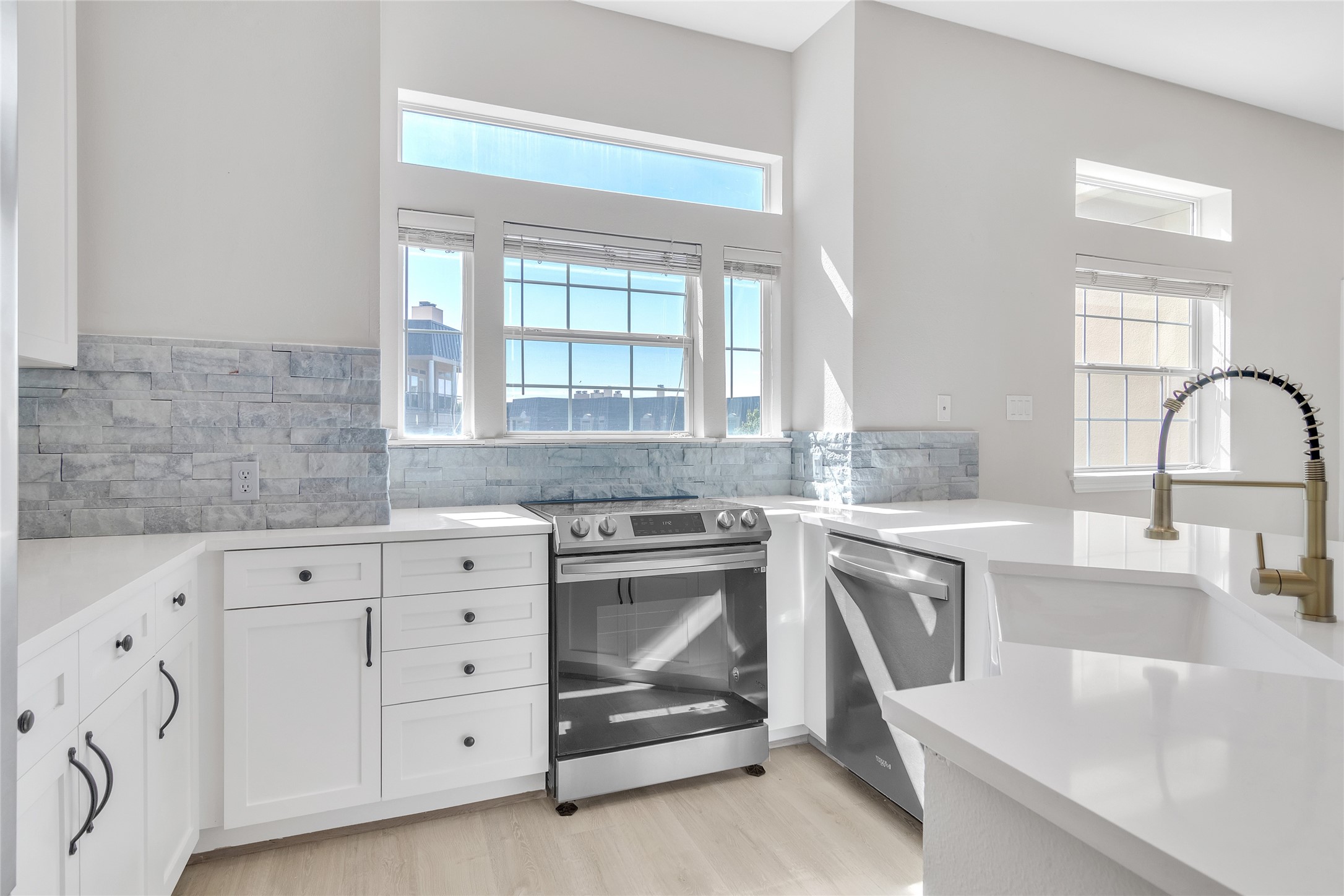 a kitchen with granite countertop white cabinets and a sink