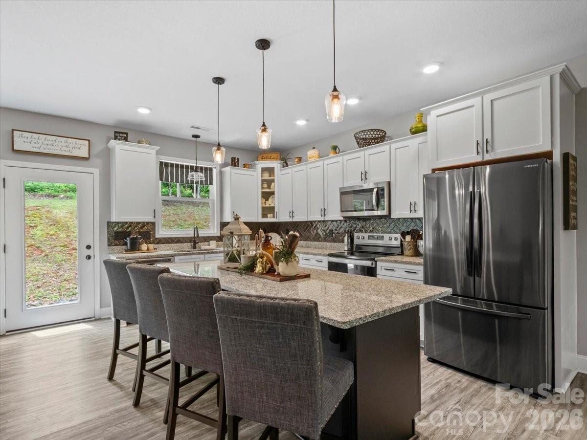 36 Cherry Ridge Lane Weaverville, NC 28787 - Photo 11 of 37 a kitchen with a refrigerator a stove a sink dishwasher with a dining table and chairs