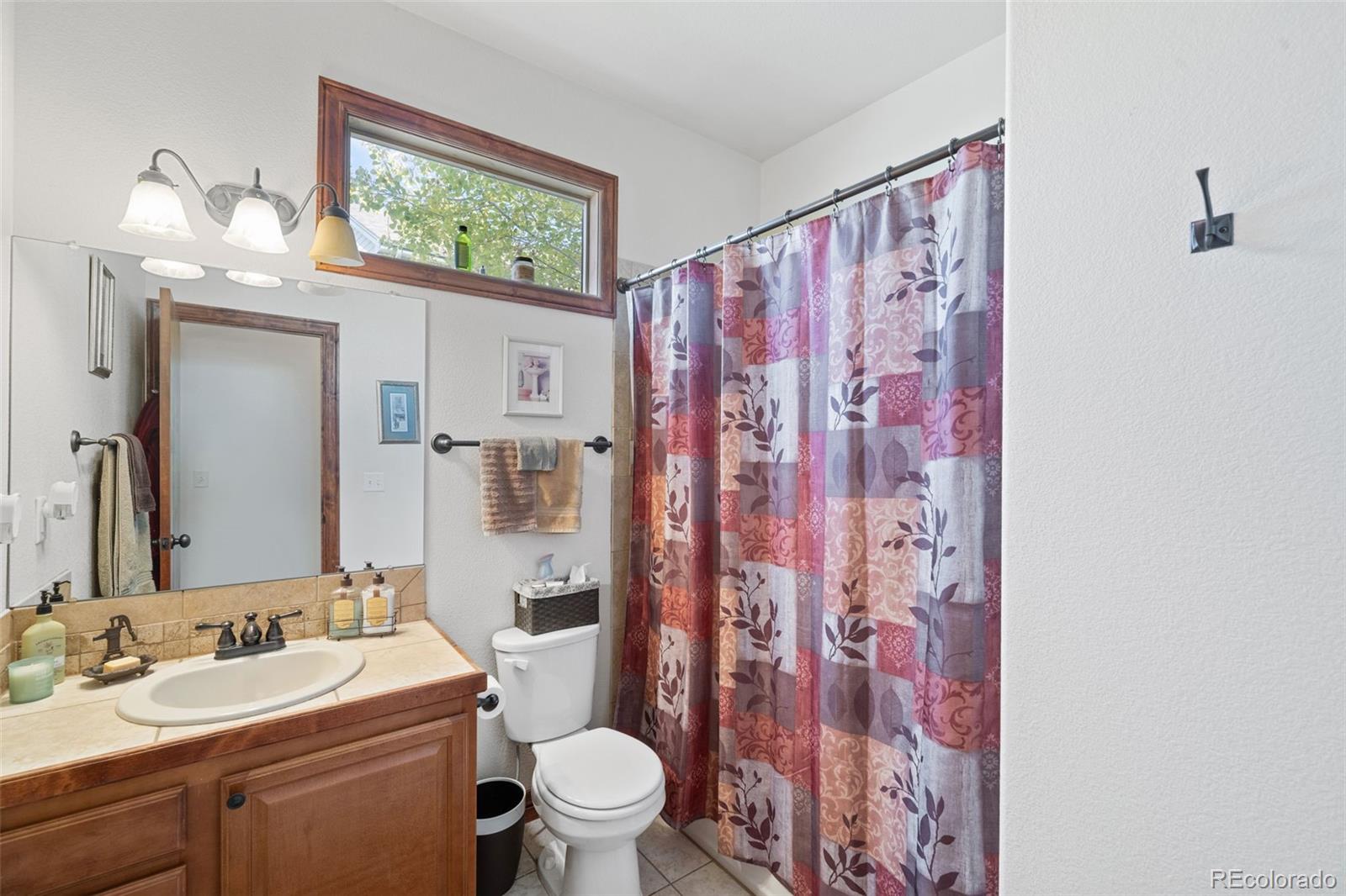 1731 Wales Drive Berthoud, CO 80513 - Photo 21 of 36 a bathroom with a sink a toilet and a mirror