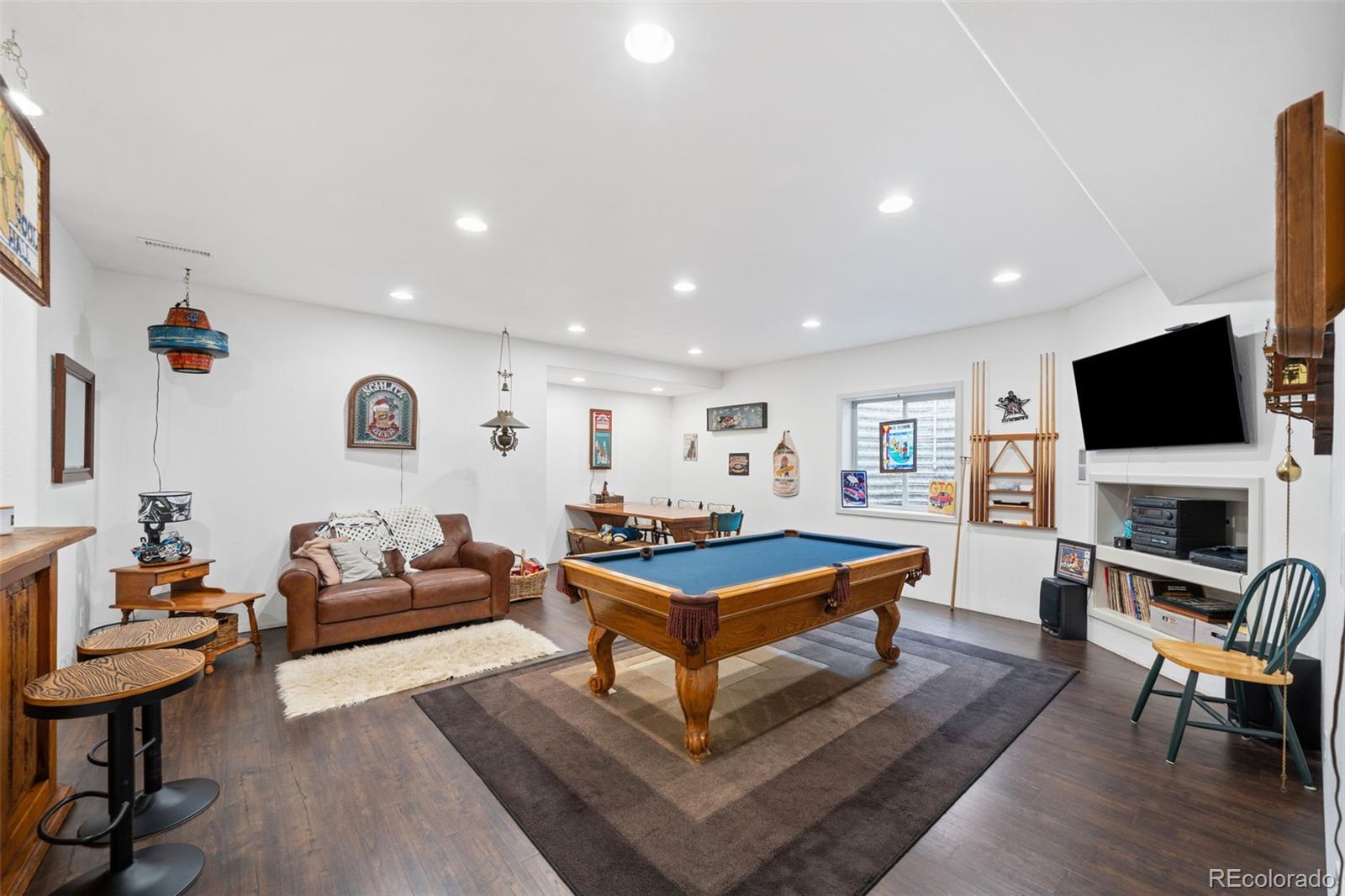 1731 Wales Drive Berthoud, CO 80513 - Photo 23 of 36 a living room with furniture a flat screen tv and kitchen view