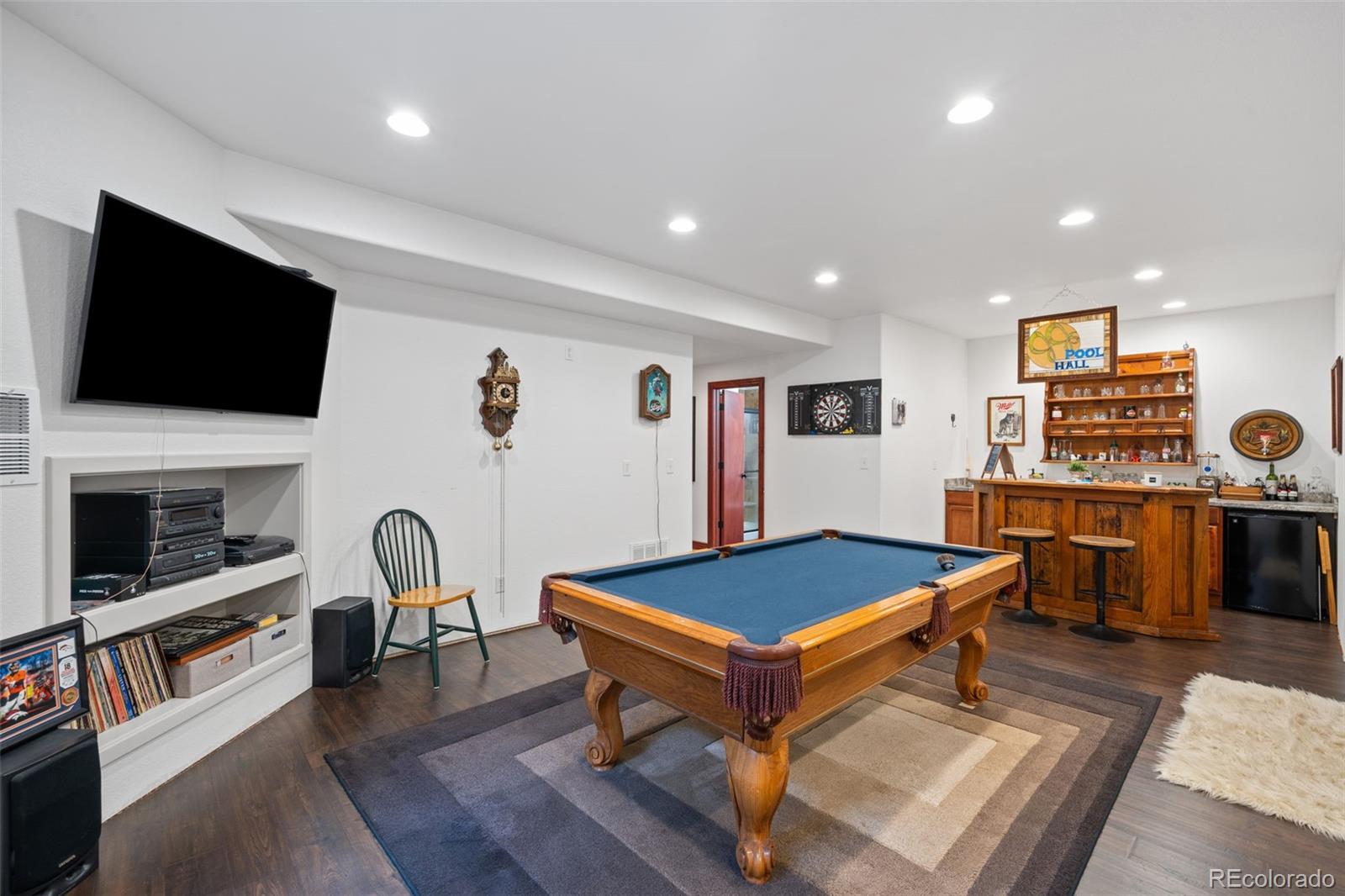 1731 Wales Drive Berthoud, CO 80513 - Photo 24 of 36 a living room with pool table flat screen tv and windows
