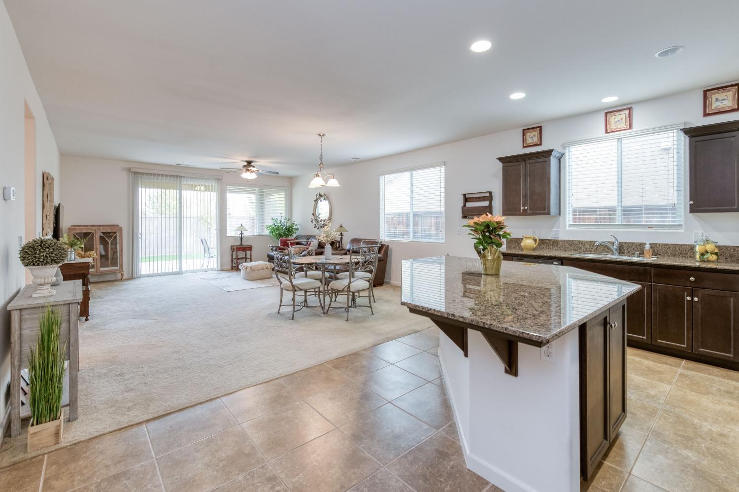 3994 Chessa Lane Clovis, CA 93619 - Photo 3 of 36 a kitchen with a stove a sink a counter top space and living room view