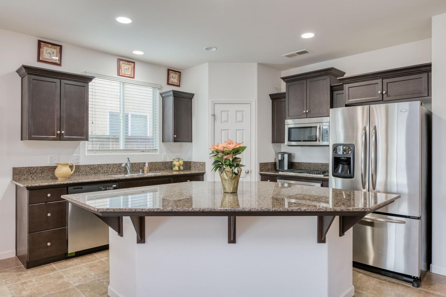 3994 Chessa Lane Clovis, CA 93619 - Photo 5 of 36 a kitchen with stainless steel appliances granite countertop a sink stove and refrigerator
