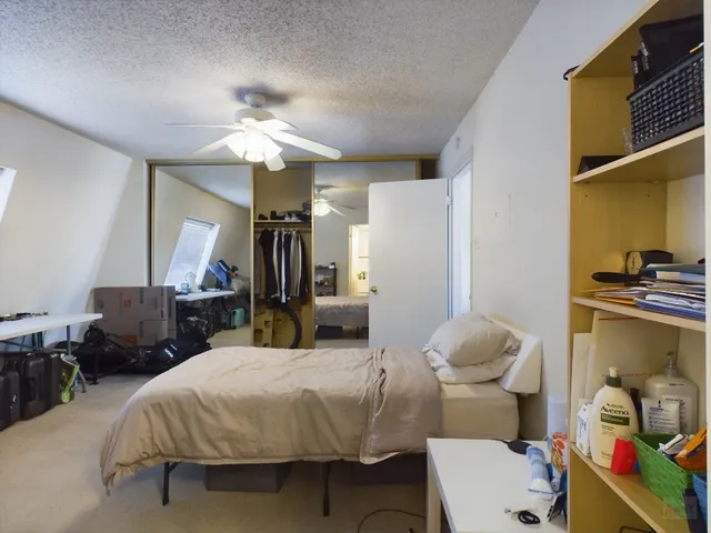 a spacious bedroom with a bed and a chandelier