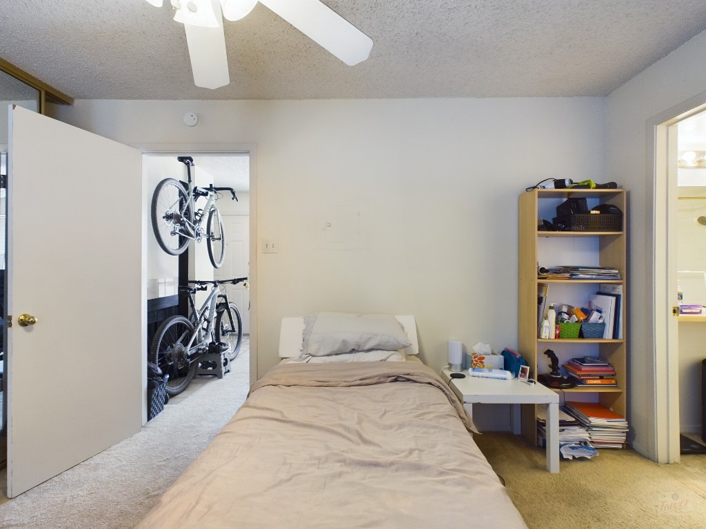 3115 Helms Street, Unit 301 Austin, TX 78705 - Photo 14 of 19 a bedroom with bed and a chandelier