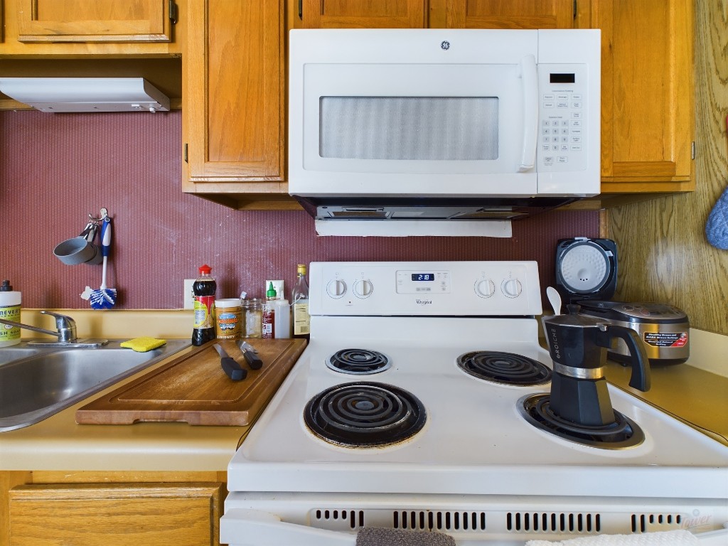 3115 Helms Street, Unit 301 Austin, TX 78705 - Photo 6 of 19 a kitchen with a stove and a wooden floor