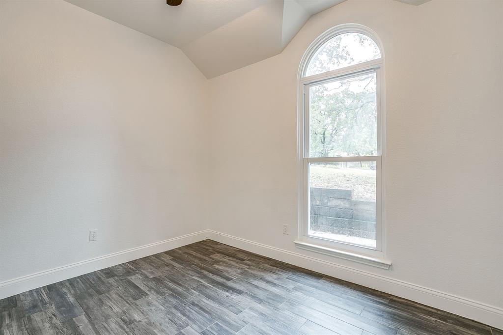 155 Ann Court Azle, TX 76020 - Photo 27 of 39 Spare room featuring vaulted ceiling and dark wood-type flooring