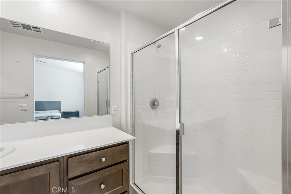 11409 Bellevue Street Adelanto, CA 92301 - Photo 32 of 49 a bathroom with a shower sink and mirror