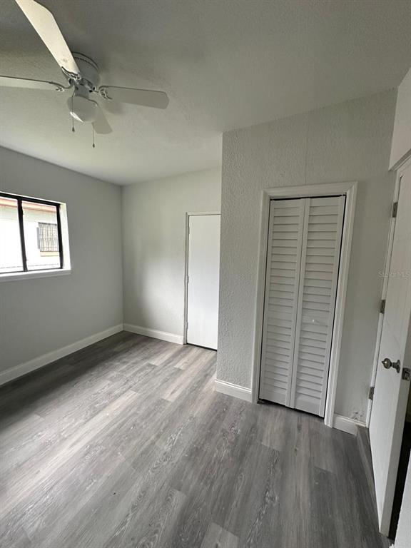 4514 Arch Street Orlando, FL 32808 - Photo 6 of 21 an empty room with wooden floor cabinet and windows