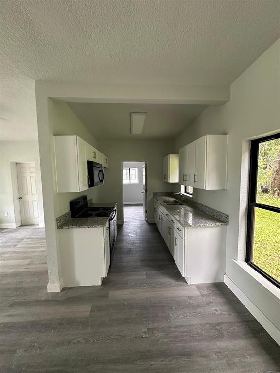 4514 Arch Street Orlando, FL 32808 - Photo 7 of 21 a kitchen with a sink and wooden floor