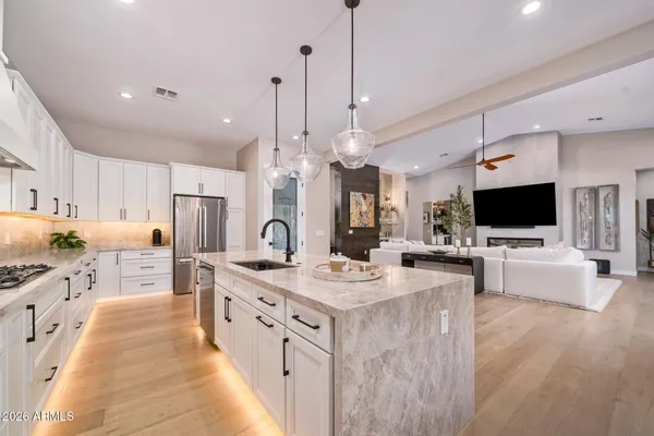 a large kitchen with kitchen island a dining table and a wooden floor