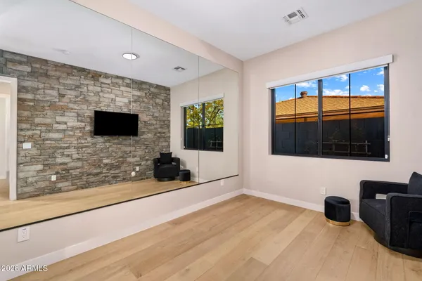 a bedroom with a bed and a dresser next to a window