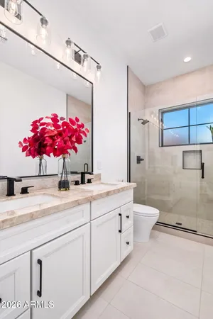 a bathroom with a granite countertop sink a toilet and shower