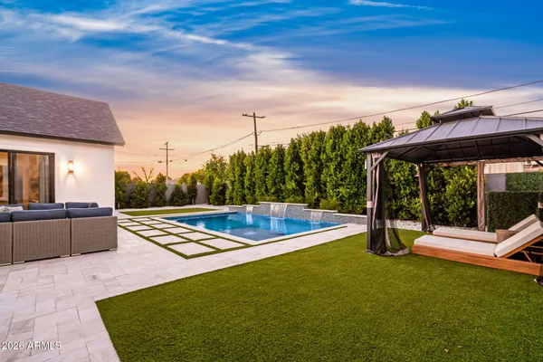 a view of a house with pool and sitting area