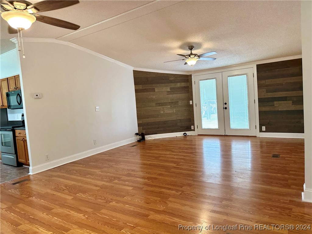 459 Nye Road Orrum, NC 28369 - Photo 19 of 25 an empty room with wooden floor chandelier fan and windows