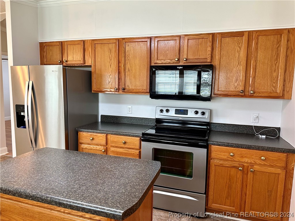 459 Nye Road Orrum, NC 28369 - Photo 7 of 25 a kitchen with stainless steel appliances granite countertop a stove a refrigerator and a microwave