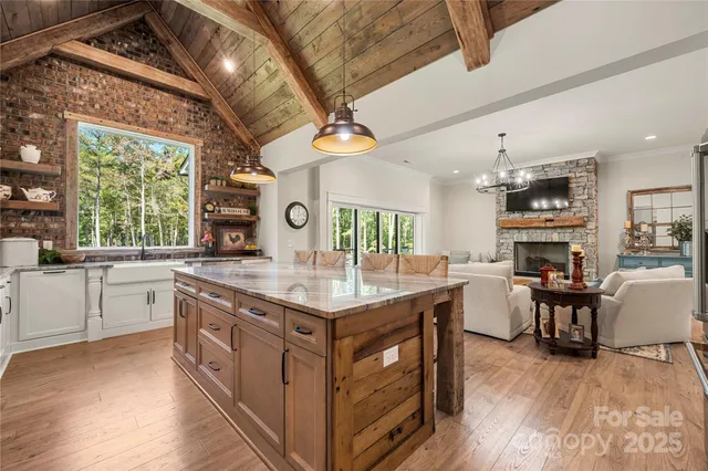 a kitchen with stainless steel appliances granite countertop a lot of counter space and a wooden floors