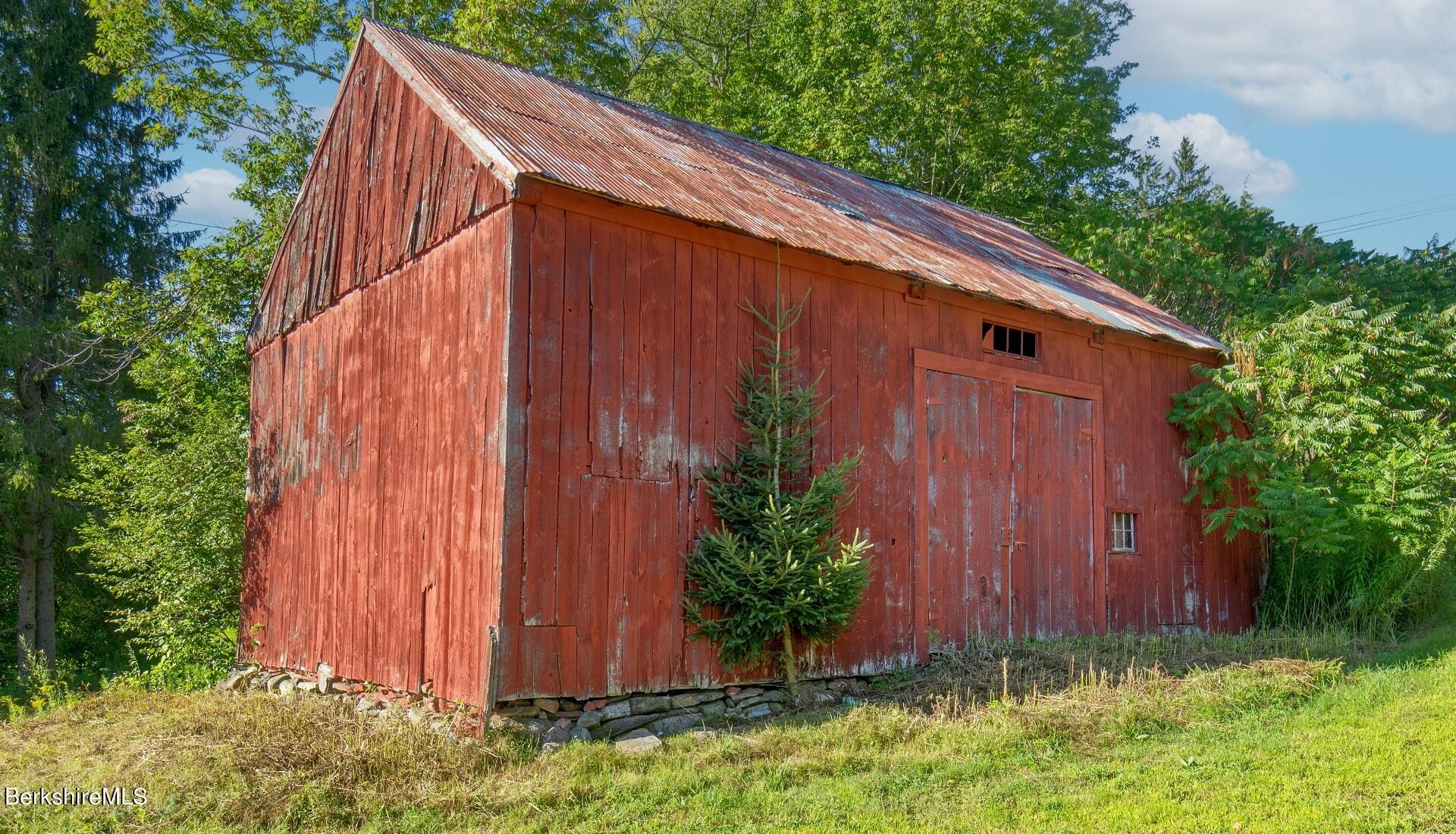 Lot 9 North Main Road Otis, MA 01253 - Photo 6 of 11 a view of barn with a small yard plants and large trees with wooden fence