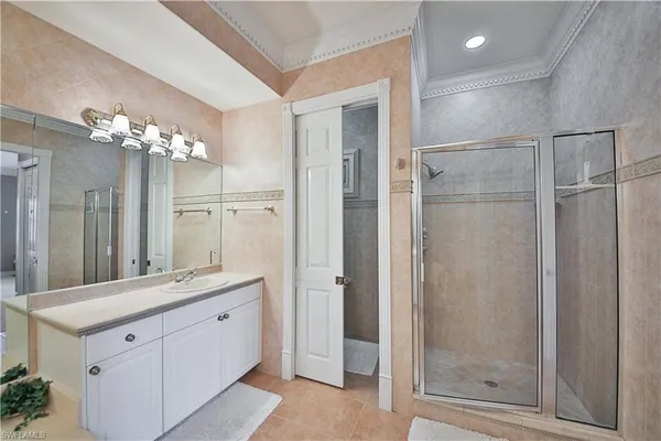a spacious bathroom with a shower sink and mirror