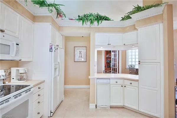 a kitchen with white cabinets and sink