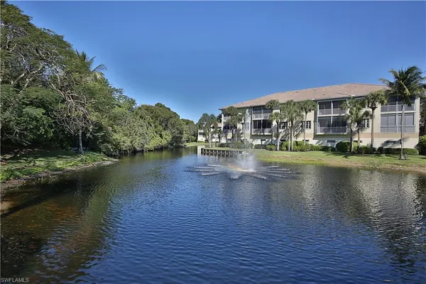a view of building with river and trees in the background