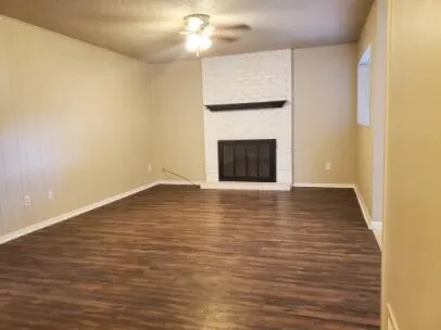 a view of empty room with wooden floor and fireplace