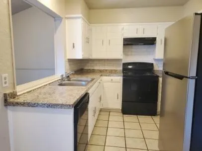 a kitchen with a sink a stove and cabinets