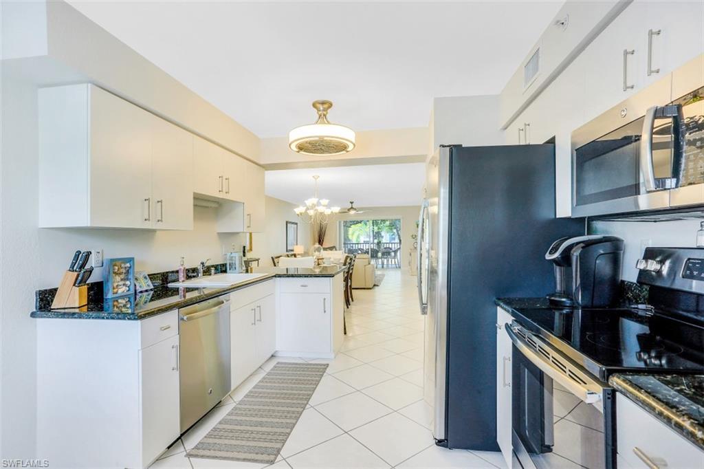 480 Bermuda Cove Way, Unit 1205 Naples, FL 34110 - Photo 12 of 33 a kitchen with stainless steel appliances granite countertop a sink and cabinets