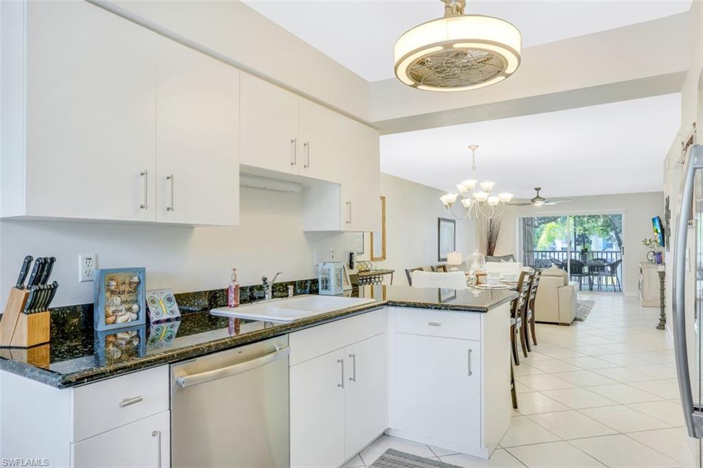 480 Bermuda Cove Way, Unit 1205 Naples, FL 34110 - Photo 13 of 33 a kitchen with white cabinets and sink