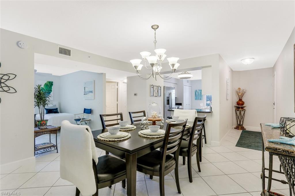 480 Bermuda Cove Way, Unit 1205 Naples, FL 34110 - Photo 15 of 33 a view of a dining room with furniture and chandelier