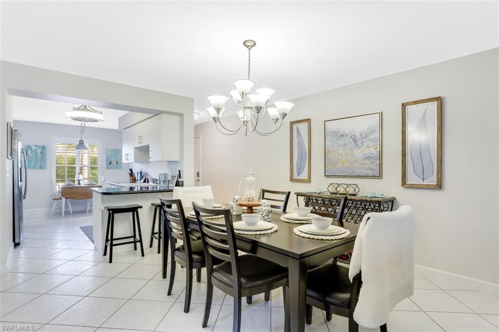 480 Bermuda Cove Way, Unit 1205 Naples, FL 34110 - Photo 16 of 33 a view of a dining room with furniture and chandelier