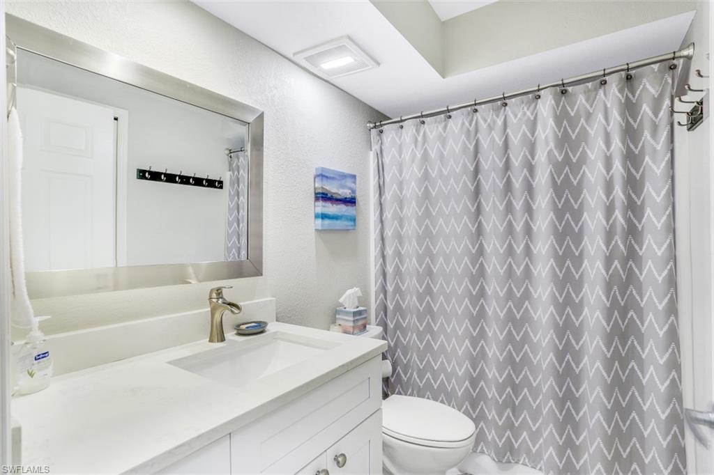 480 Bermuda Cove Way, Unit 1205 Naples, FL 34110 - Photo 22 of 33 a bathroom with a sink a toilet and shower curtain