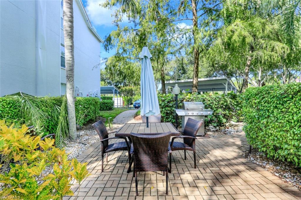 480 Bermuda Cove Way, Unit 1205 Naples, FL 34110 - Photo 26 of 33 a view of a patio with table and chairs and potted plants