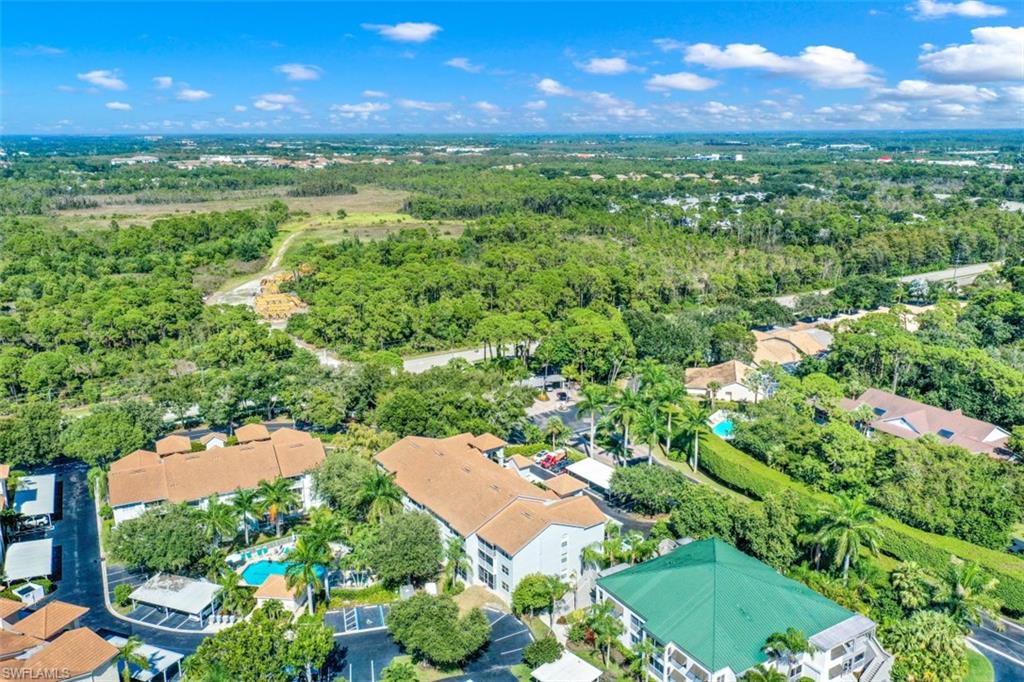 480 Bermuda Cove Way, Unit 1205 Naples, FL 34110 - Photo 29 of 33 a view of a yard with plants and outdoor seating