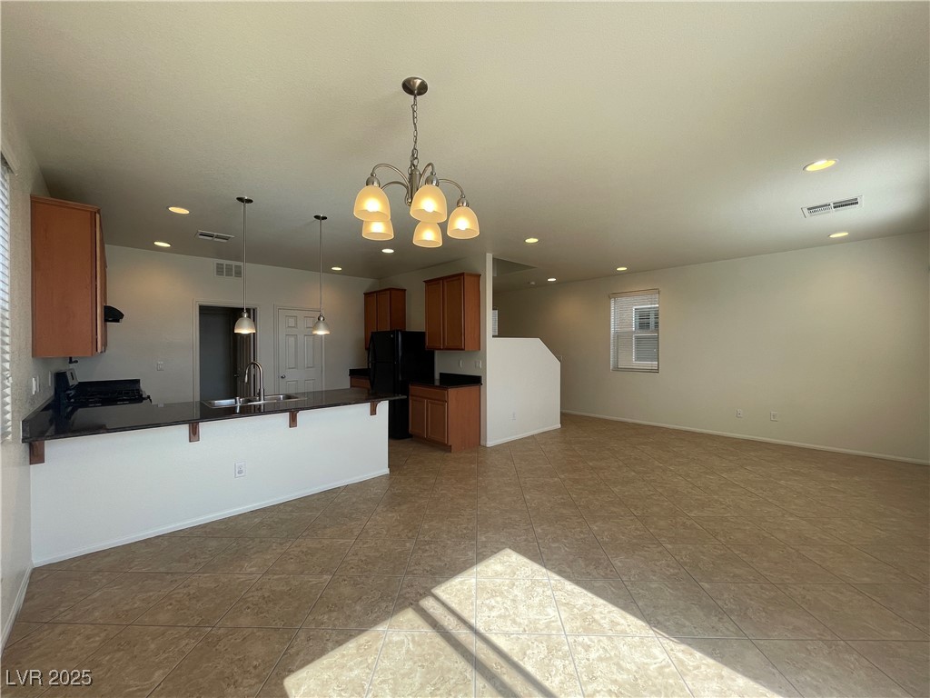10632 Summerbell Street Las Vegas, NV 89179 - Photo 16 of 16 Kitchen featuring freestanding refrigerator, dark countertops, open floor plan, a peninsula, and recessed lighting