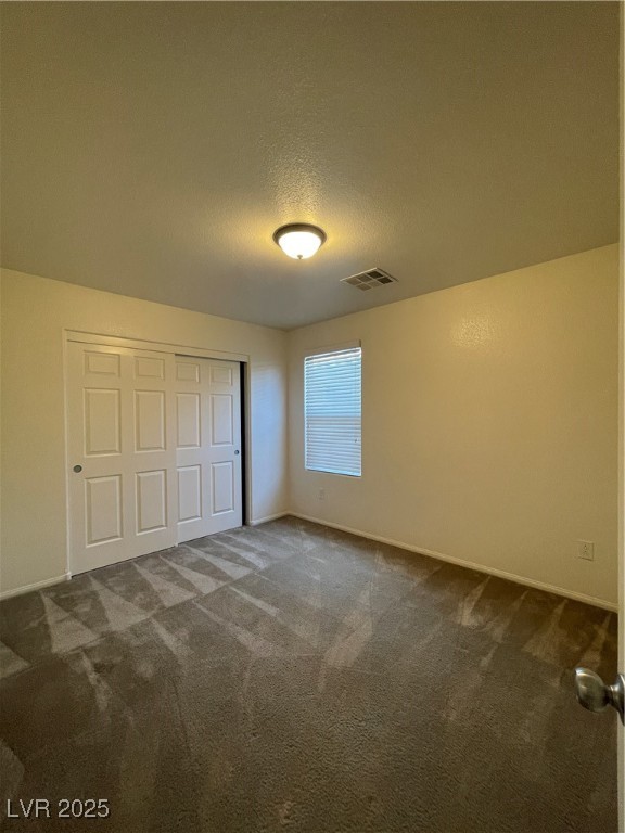 10632 Summerbell Street Las Vegas, NV 89179 - Photo 7 of 16 Unfurnished bedroom with carpet flooring, a closet, and a textured ceiling
